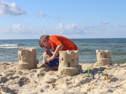 Kid building a sandcastle on the beach in Gulf Shores