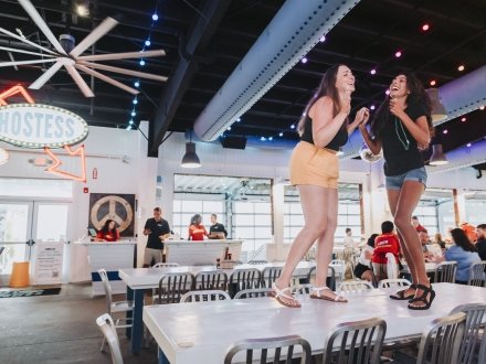 Friends dancing on the table at The Hangout beach restaurant in Gulf Shores