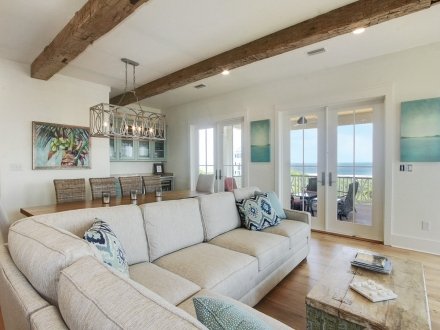 Coastal-style Beach House Rental in Gulf Shores, Alabama, featuring open living spaces, rustic beams, and stunning ocean views