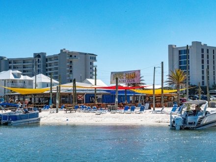 Pontoon boats parked at Flora-Bama Yacht Club waterfront restaurant in Orange Beach