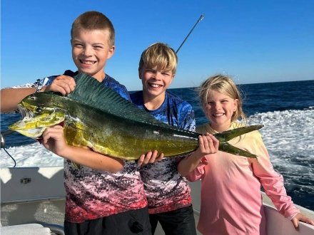 Kids holding up a mahi caught on a family Orange Beach fishing charter 