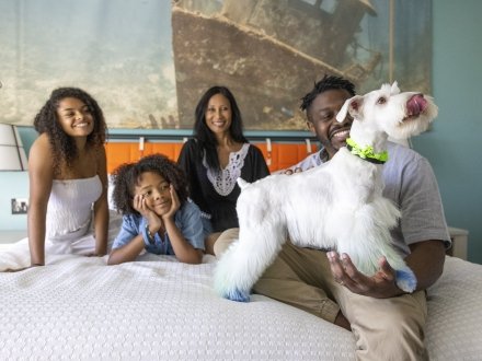 A family enjoying their hotel on Alabama's Beaches that is pet-friendly"]