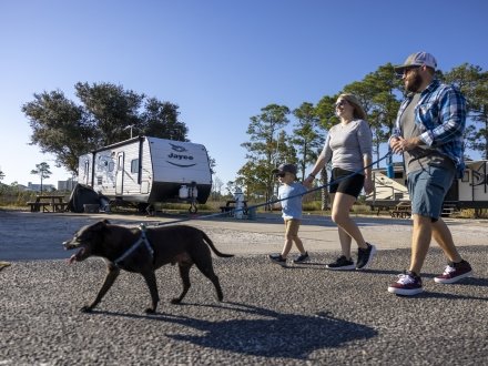 A family enjoying their RV park rental with their pet on an Alabama's Beaches vacation