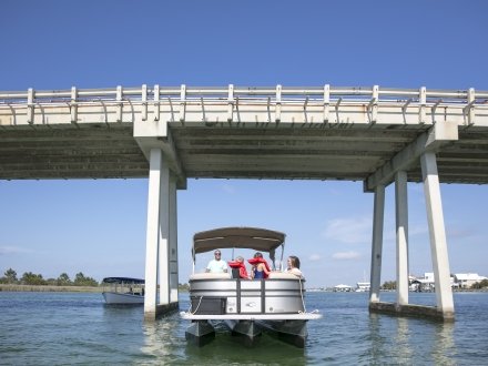 Family on a pontoon boat rental cruising the waterways in Orange Beach