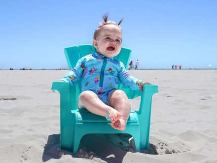 Baby sitting in a small beach chair at the beach in Gulf Shores