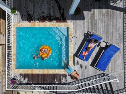 Aerial view of family enjoying a private pool at a beach house in orange beach