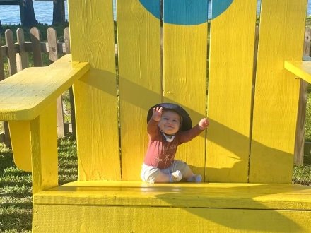 Baby sitting in big Adirondack chair at GTs family-friendly restaurant in Orange Beach