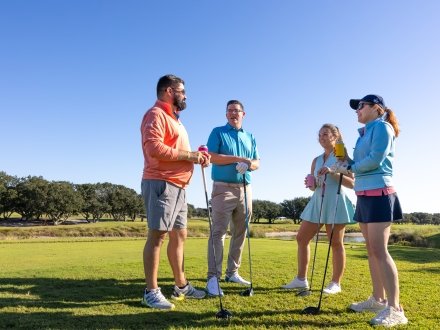 Friends playing golf at Kiva Dunes