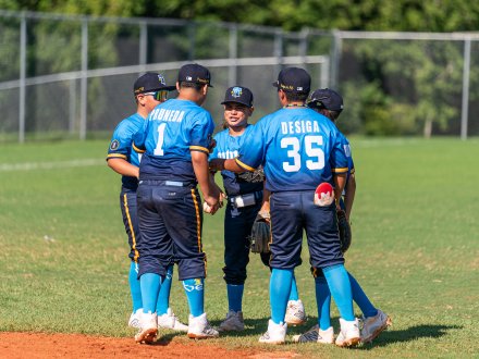 Players huddling up while playing baseball on Alabama's Beaches