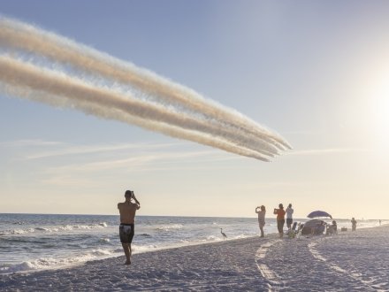 People on the beach watching the Blue Angels fly over the Gulf in Orange Beach