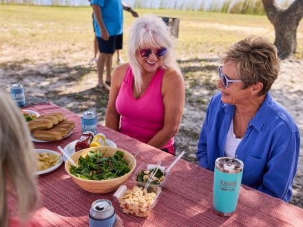 Friends having a waterfront picnic at Lake Shelby in Gulf State Park