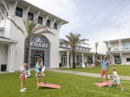 Family playing corn hole at Portside at The Wharf