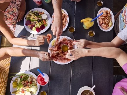 Hands grabbing royal red shrimp at Sea-N-Suds seafood restaurant in Gulf Shores