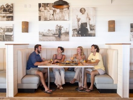 Friends dining at a booth inside Coastal beachfront restaurant in Orange Beach