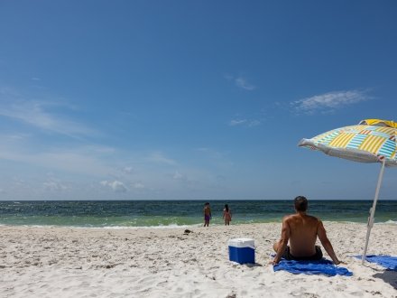Dad and kids relaxing on the beach in Gulf Shores