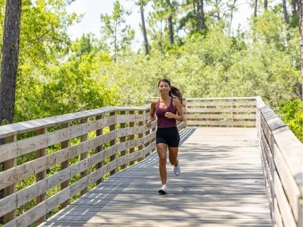Woman running along boardwalk trails in Gulf State Park