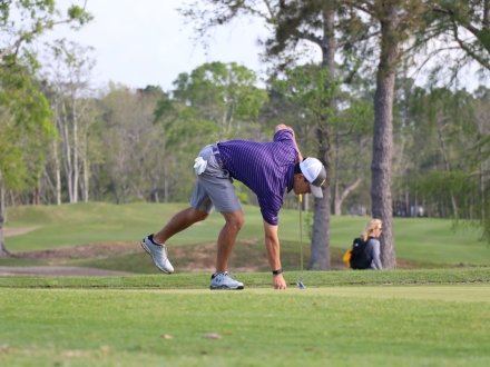 Man picking up a golf ball on the course at Craft Farms in Gulf Shores