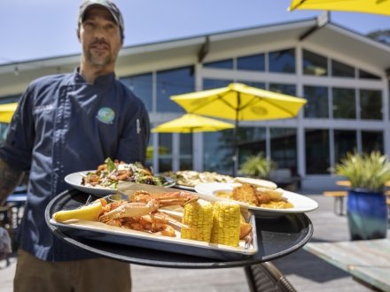 Waiter holding a platter of seafood at GTs on the Bay Orange Beach restaurant