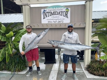 Two anglers holding wahoo caught on a fishing charter in Orange Beach