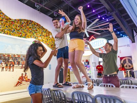 Friends dancing on the tables at The Hangout beachfront bar in Gulf Shores