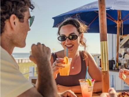 Friends sipping craft cocktails at Coastal beachfront bar and restaurant in Orange Beach