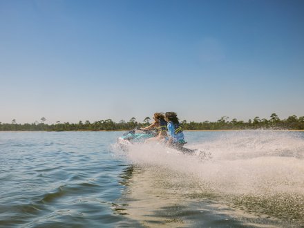 Couple riding a jet ski in the back bays of Orange Beach
