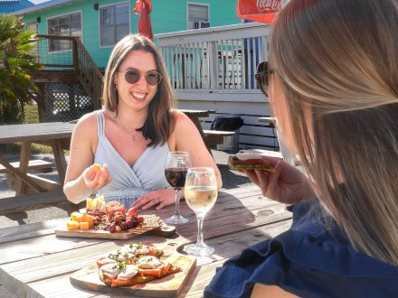 Girlfriends dining and sipping wine at Lauria's by the Beach Italian restaurant in Gulf Shores