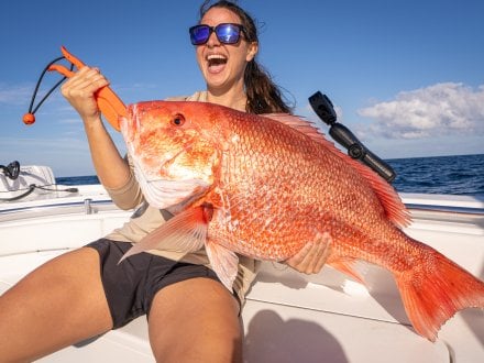Lady angler catching a red snapper on Alabama's Beaches