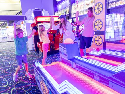 Family playing arcade games at The Track Gulf Shores attraction