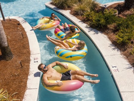 Friends floating in the lazy river at Beach Village Resort beach house community in Orange Beach