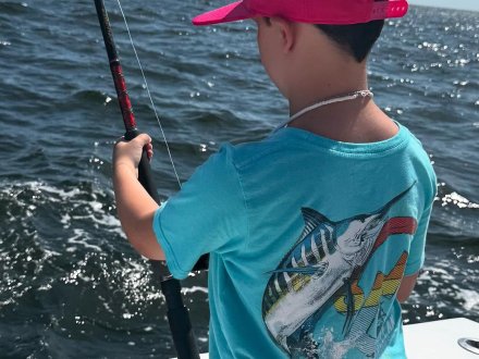 Kid fishing on a fishing charter boat in Orange Beach