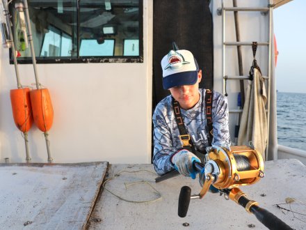 boy fishing from an offshore charter boat in orange beach