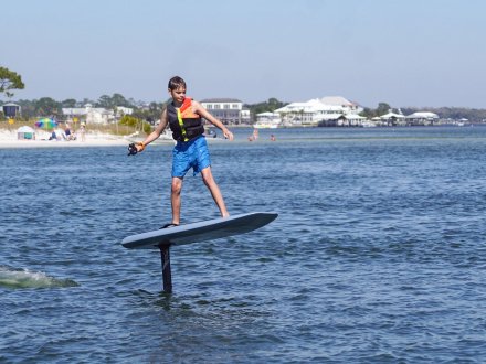 Boy efoiling in orange beach, thrilling watersport activity