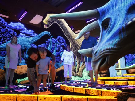Family with toddler playing mini golf at Jurassic Golf in Gulf Shores