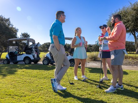 Friends hanging out on the golf course at Kiva Dunes Golf Resort in Fort Morgan