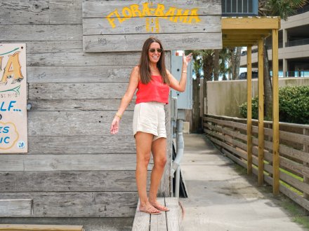 Woman standing on the stateline at the iconic Flora-Bama beach bar in Orange Beach