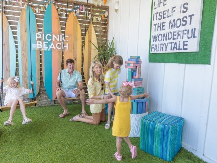 Family playing on the grassy turf at Picnic Beach family restaurant in Gulf Shores