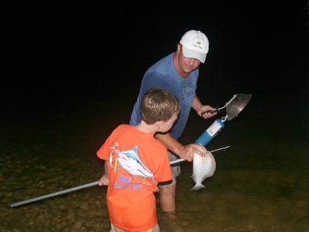 Dad and son flounder gigging night fishing