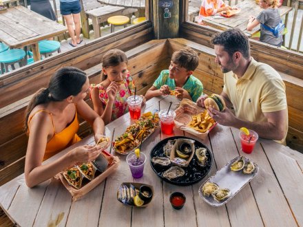 Family dining at Tiki & Raw Bar waterfront restaurant in Orange Beach