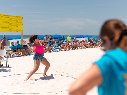Woman throwing fish at Flora-Bama's Annual Mullet Toss festival in Orange Beach