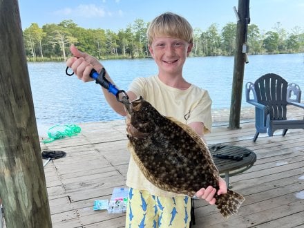 Boy holding a flounder caught while inshore fishing 