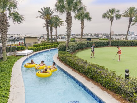 Family floating in lazy river at Phoenix on the Bay condos in Orange Beach