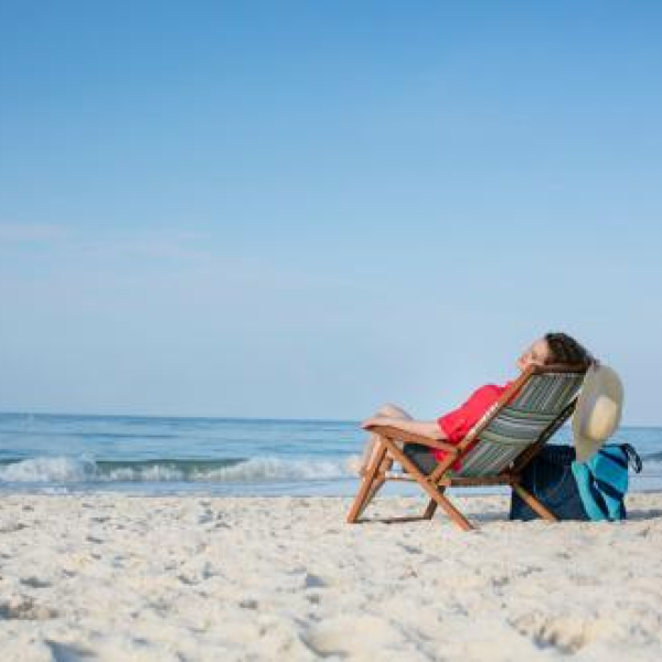 Woman relaxing in a beach chair on the shore of Orange Beach