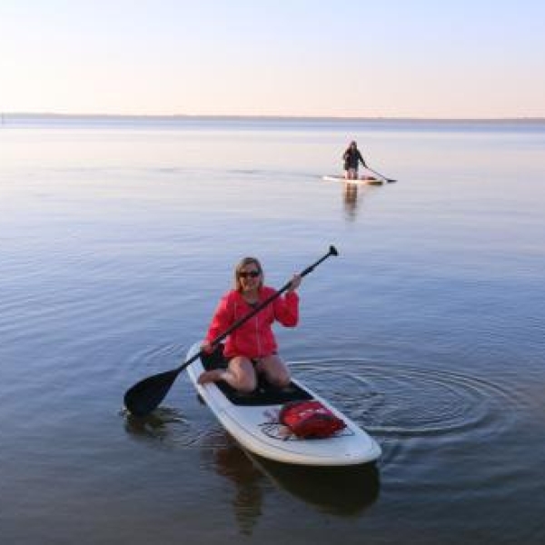 women paddle boarding along the back bays in Orange Beach