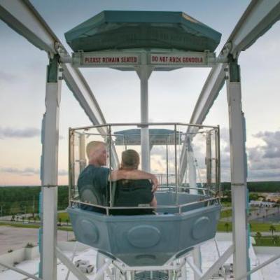 Couple riding the Ferris wheel at The Wharf during sunset