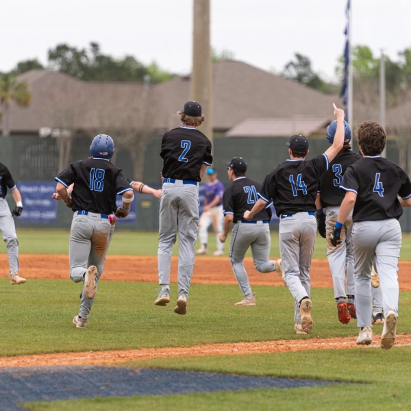 High school baseball team celebrating on field after a win in Gulf Shores