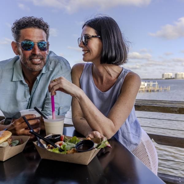 Couple enjoying some food and drinks while on a data on Alabama's Beaches