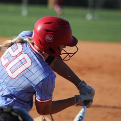 Softball player swinging at ball