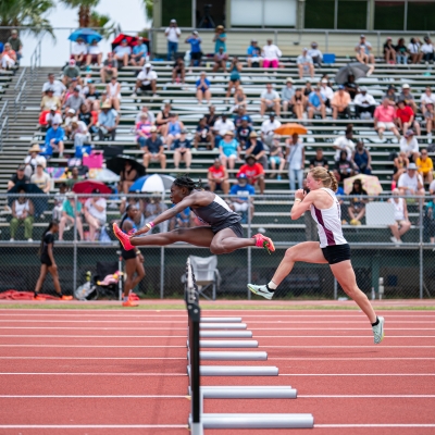 Athletes crossing over hurdles during the AHSSA State Track Championship on Alabama's Beaches