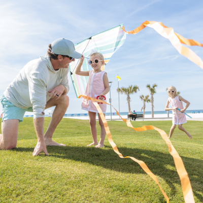 Family flying kites on the grassy lawn at Gulf Place